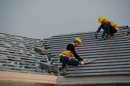 Roofers with safety harnesses